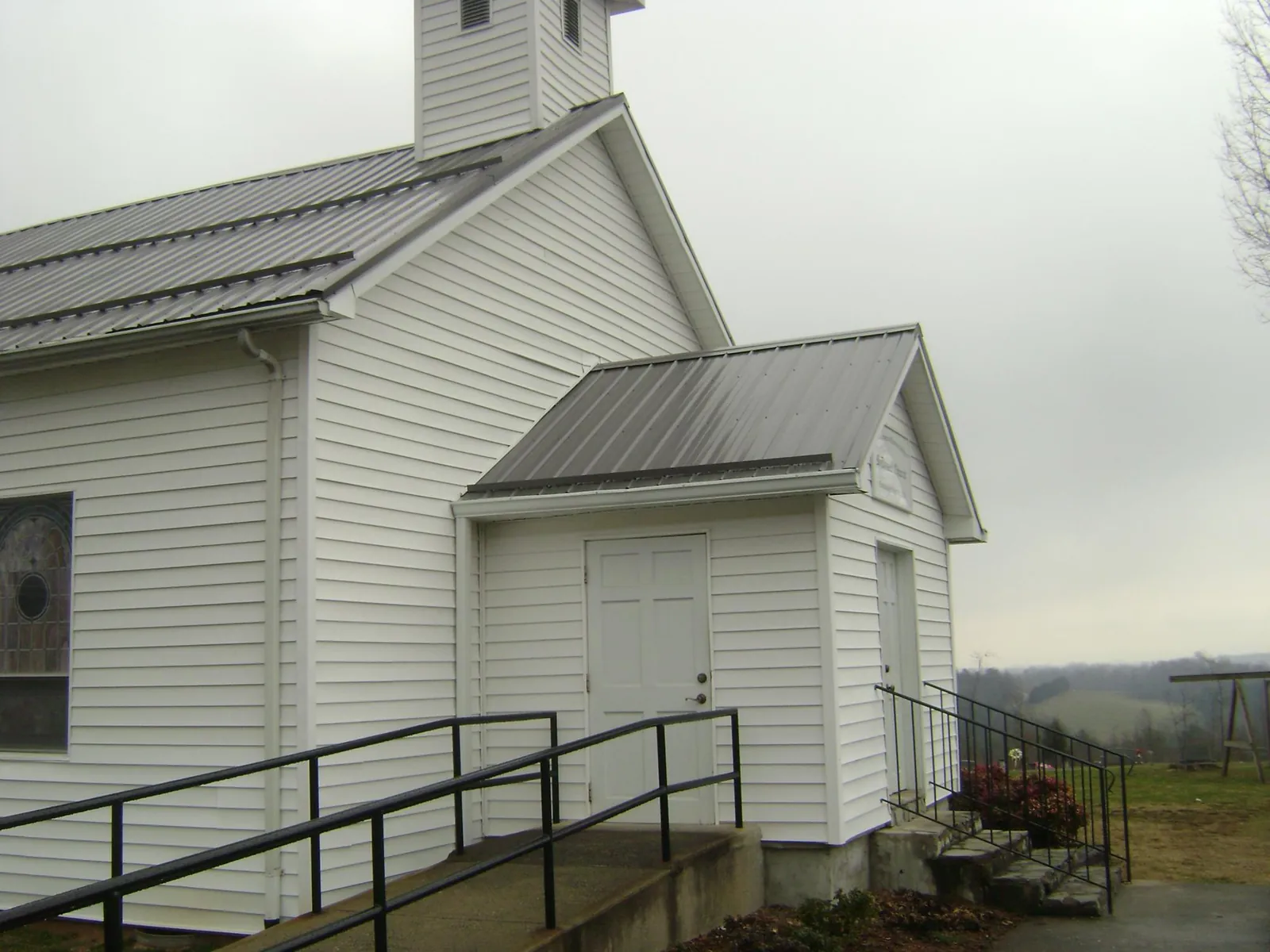 Gray metal roof on a white clapboard church with a steeple in La Mirada